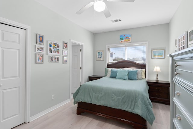 bedroom with light wood-style flooring, visible vents, ceiling fan, and baseboards