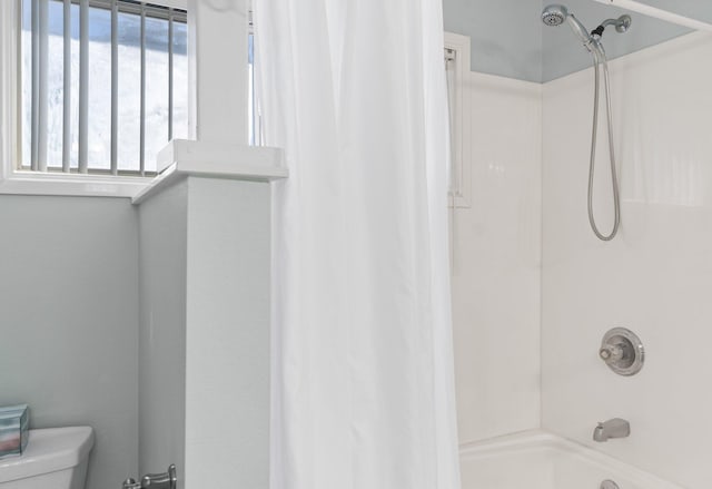 full bathroom with shower / bath combo with shower curtain and toilet