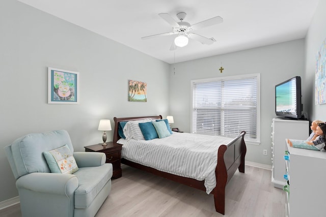 bedroom featuring ceiling fan, light wood-style flooring, and baseboards