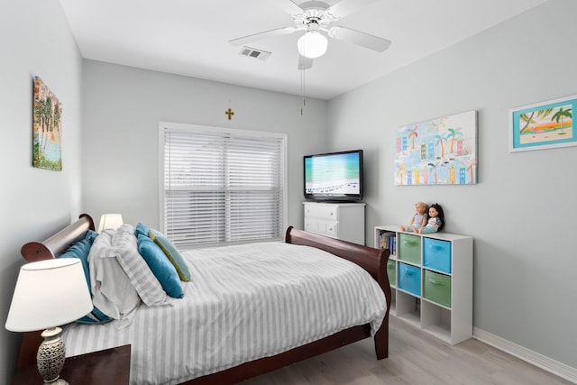 bedroom with ceiling fan, wood finished floors, visible vents, and baseboards