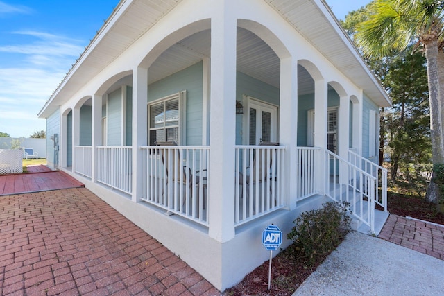 view of side of property featuring covered porch