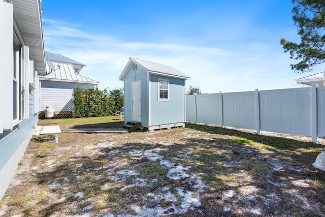 view of yard featuring an outbuilding, a fenced backyard, and a shed