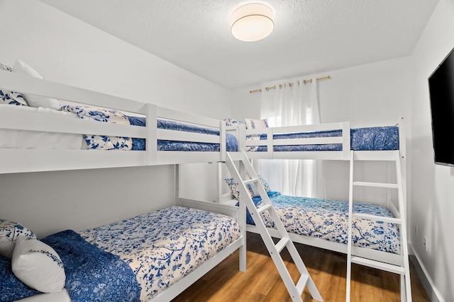 bedroom with a textured ceiling and wood finished floors