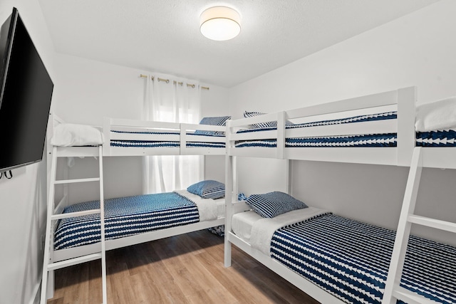 bedroom with wood finished floors and a textured ceiling