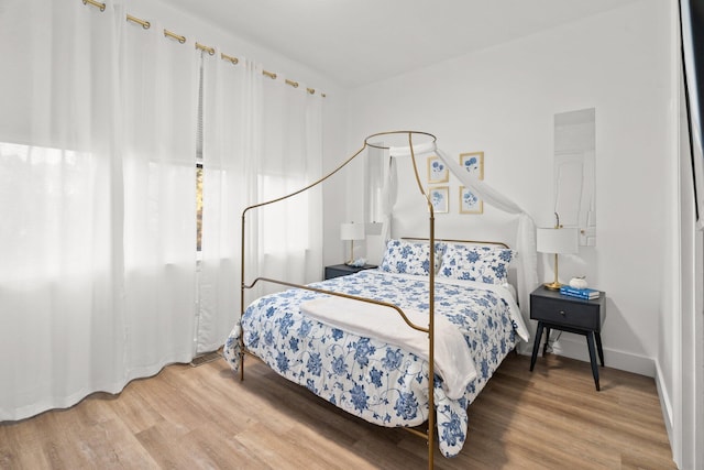 bedroom featuring baseboards and wood finished floors