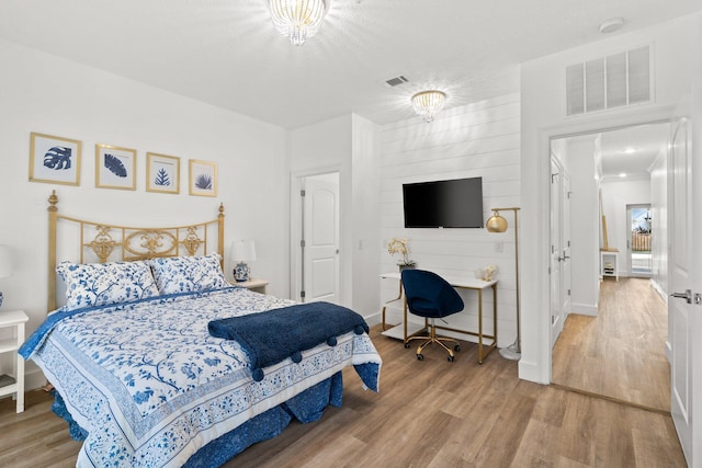 bedroom with visible vents, baseboards, and wood finished floors