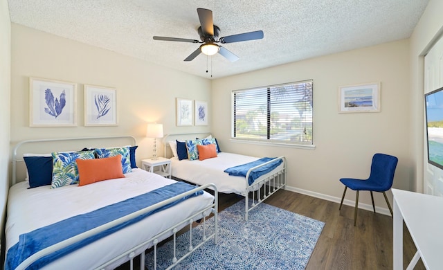 bedroom with a ceiling fan, a textured ceiling, baseboards, and wood finished floors