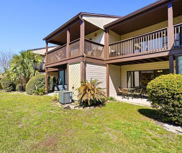 rear view of property with a patio area, a yard, and central AC