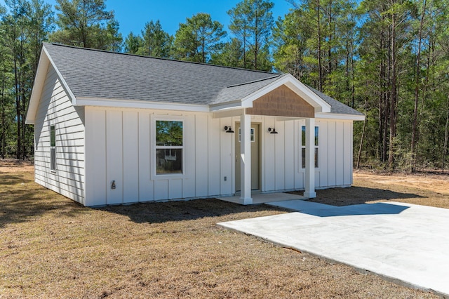 view of front of property featuring board and batten siding and roof with shingles