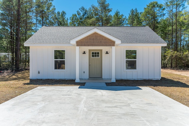 modern inspired farmhouse with a shingled roof and board and batten siding