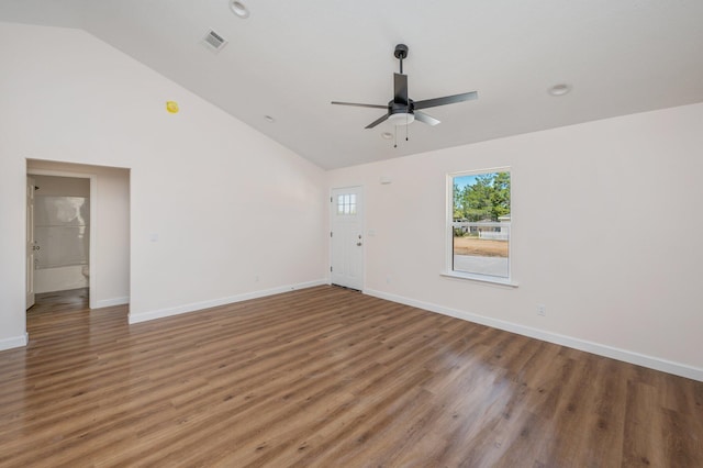 spare room featuring light wood-style floors, baseboards, visible vents, and high vaulted ceiling