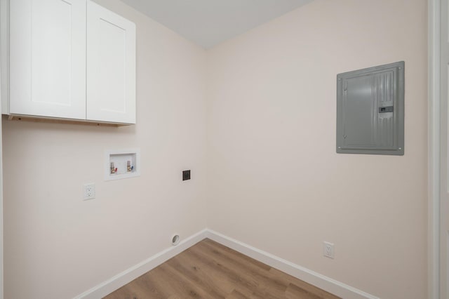 laundry area with hookup for a washing machine, light wood-style floors, baseboards, cabinet space, and electric panel