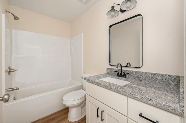 full bathroom with washtub / shower combination, vanity, wood finished floors, and toilet