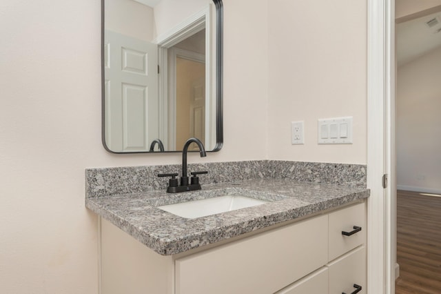 bathroom featuring vanity, baseboards, and wood finished floors