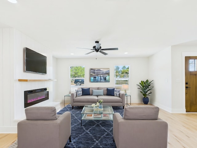 living area with ceiling fan, baseboards, recessed lighting, wood finished floors, and a glass covered fireplace