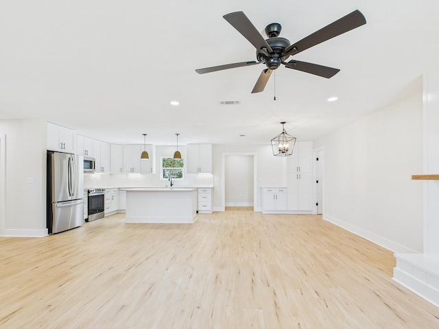 kitchen with visible vents, stainless steel appliances, light wood-style floors, white cabinets, and light countertops