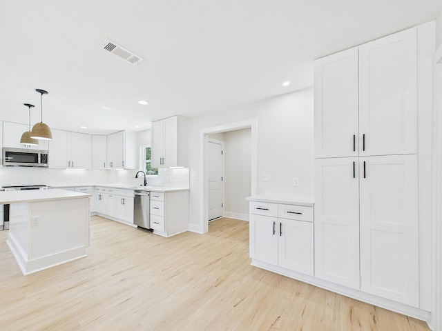 kitchen featuring visible vents, light wood-style flooring, light countertops, white cabinets, and appliances with stainless steel finishes