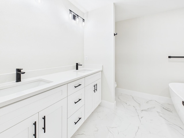 bathroom featuring a sink, baseboards, and marble finish floor