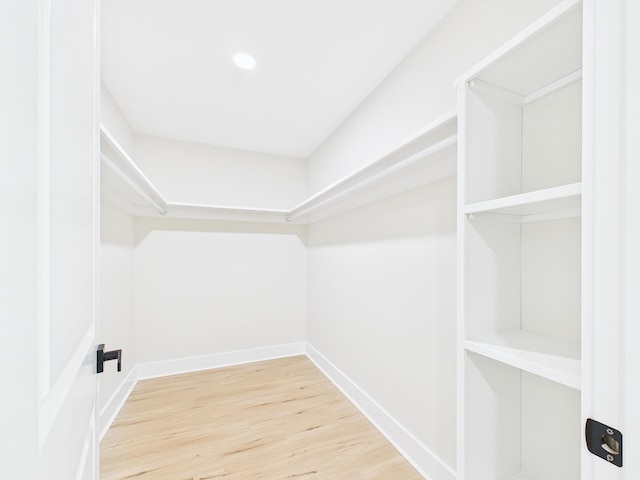 walk in closet with wood finished floors