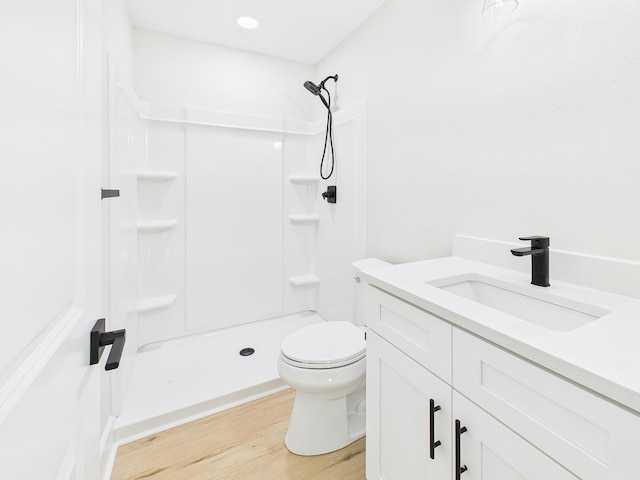 full bath with a shower stall, toilet, vanity, and wood finished floors