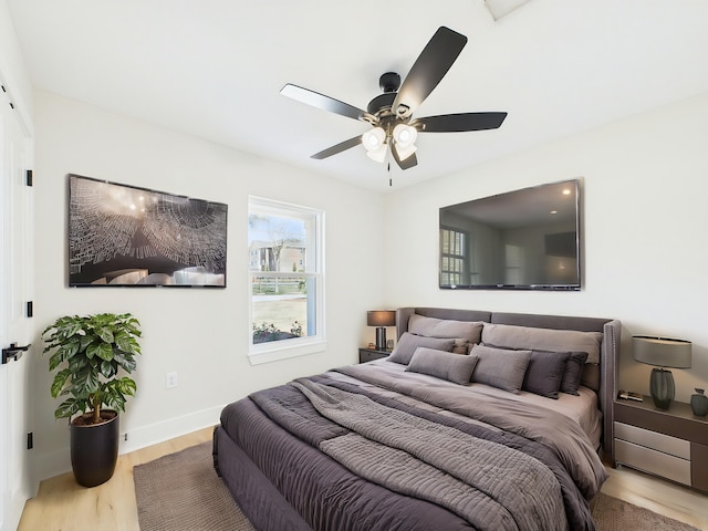 bedroom with ceiling fan, baseboards, and wood finished floors