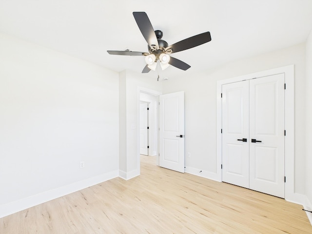 unfurnished bedroom featuring a closet, baseboards, light wood-style flooring, and a ceiling fan