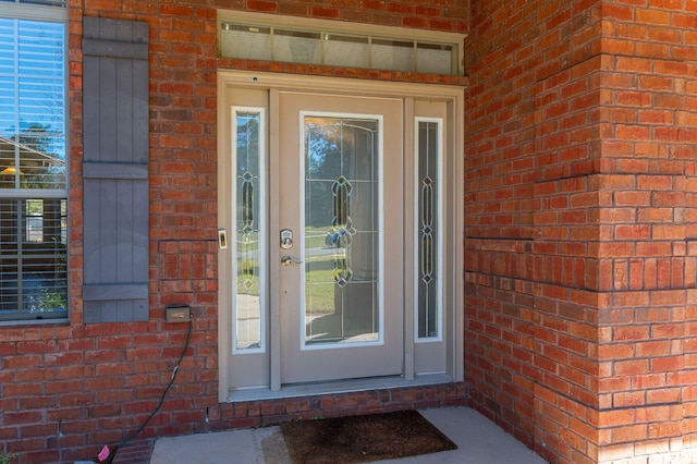 view of exterior entry with brick siding