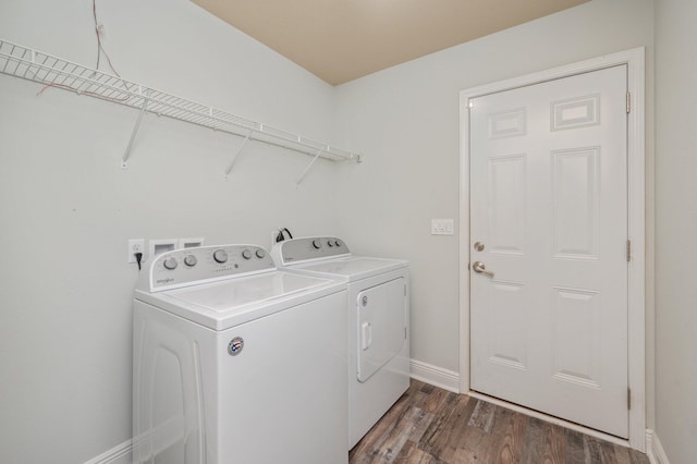 laundry area with washer and dryer, laundry area, dark wood finished floors, and baseboards