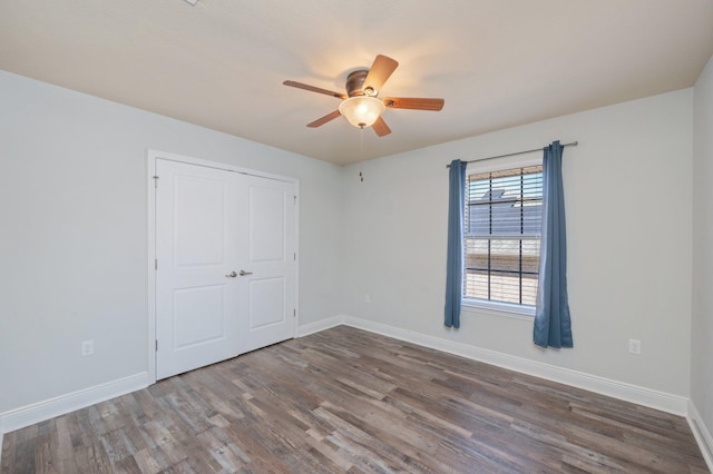 unfurnished bedroom featuring ceiling fan, baseboards, and wood finished floors