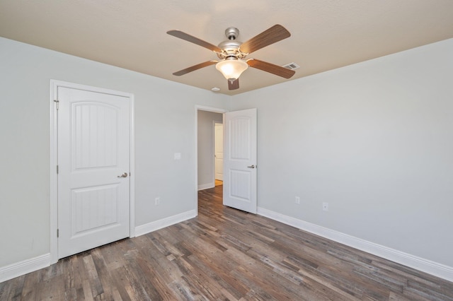 unfurnished bedroom featuring baseboards, visible vents, ceiling fan, and wood finished floors