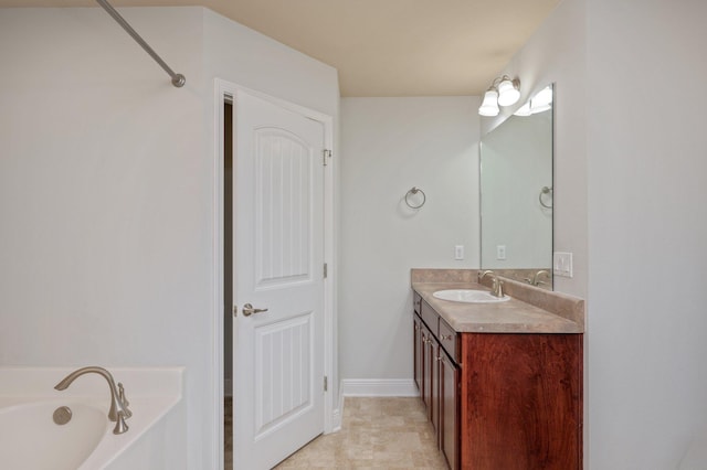 full bathroom with vanity, baseboards, and a bath