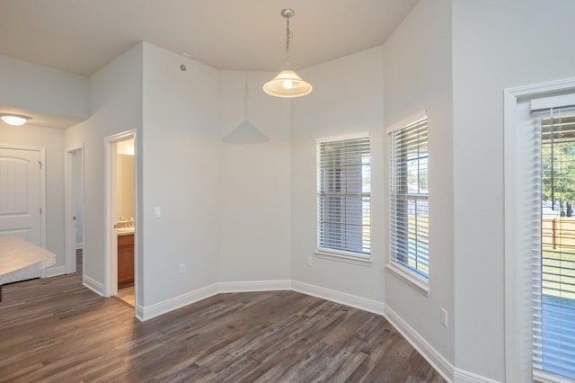 empty room featuring dark wood-type flooring and baseboards