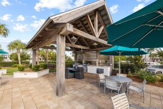 view of patio with a gazebo, area for grilling, outdoor dining space, and fence