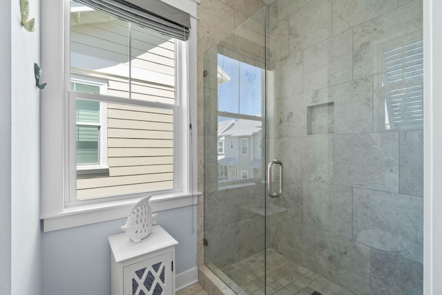 full bathroom featuring plenty of natural light and a shower stall