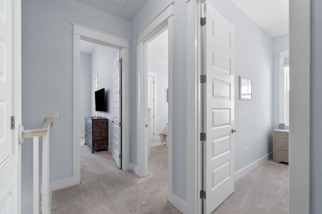 hall with light carpet and baseboards