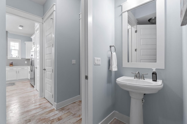 bathroom with wood finished floors and baseboards