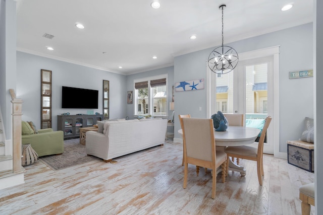 dining area featuring visible vents, crown molding, light wood-type flooring, recessed lighting, and an inviting chandelier