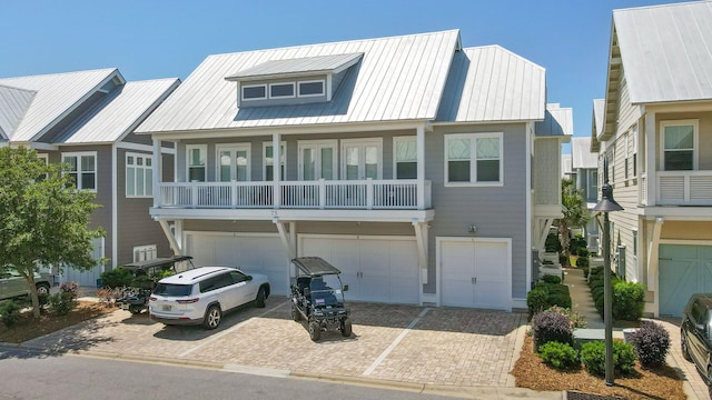 view of property featuring an attached garage, metal roof, and decorative driveway