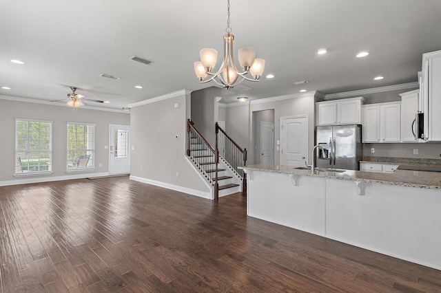 kitchen featuring visible vents, dark wood finished floors, a kitchen breakfast bar, stainless steel appliances, and a sink