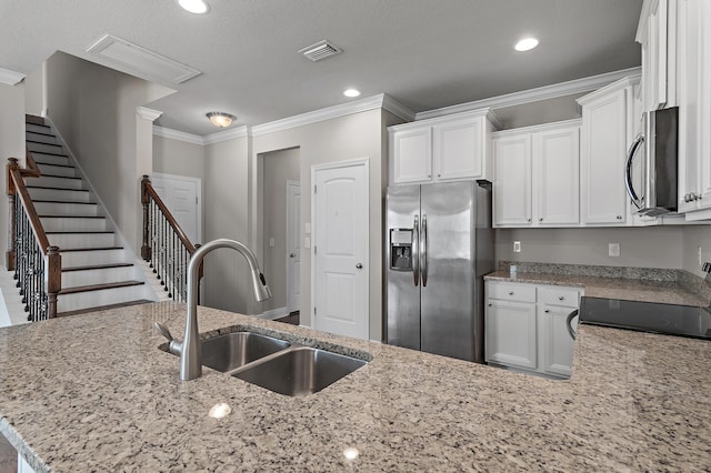 kitchen with crown molding, appliances with stainless steel finishes, white cabinetry, a sink, and light stone countertops