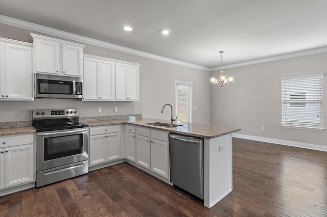 kitchen featuring dark wood-style flooring, a peninsula, stainless steel appliances, crown molding, and a sink