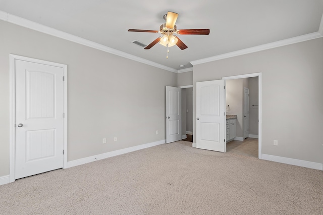 unfurnished bedroom featuring ensuite bathroom, light colored carpet, visible vents, baseboards, and ornamental molding