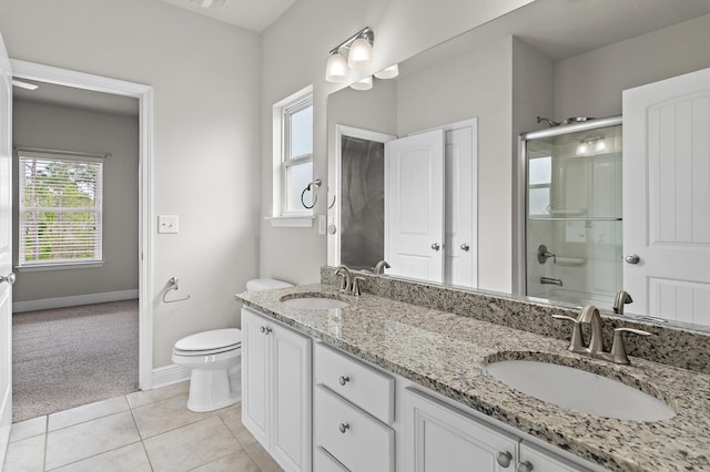 bathroom featuring toilet, tile patterned flooring, a sink, and a shower with shower door