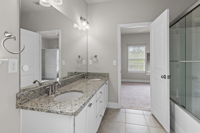 full bathroom featuring tile patterned flooring, combined bath / shower with glass door, a sink, and double vanity