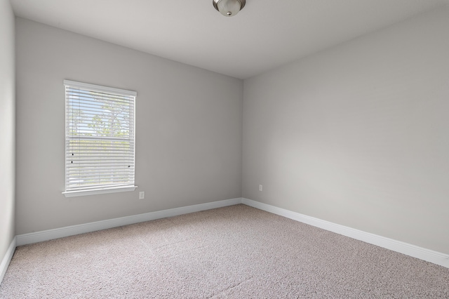 unfurnished room with carpet and baseboards