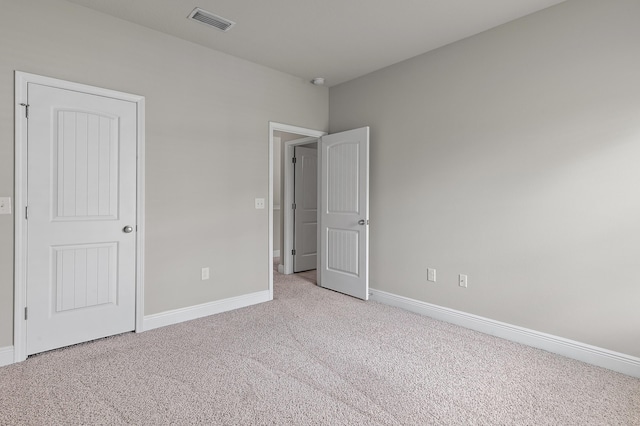 unfurnished bedroom featuring carpet floors, visible vents, and baseboards