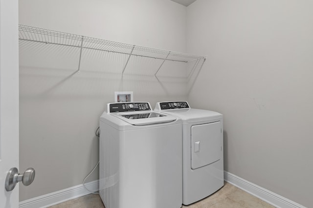 laundry room featuring laundry area, washing machine and dryer, and baseboards