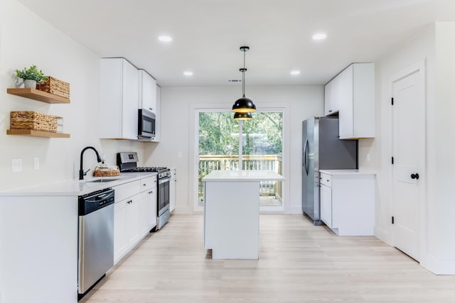 kitchen featuring white cabinets, a center island, stainless steel appliances, open shelves, and a sink