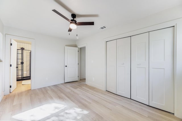 unfurnished bedroom featuring baseboards, visible vents, ensuite bath, light wood-type flooring, and a closet