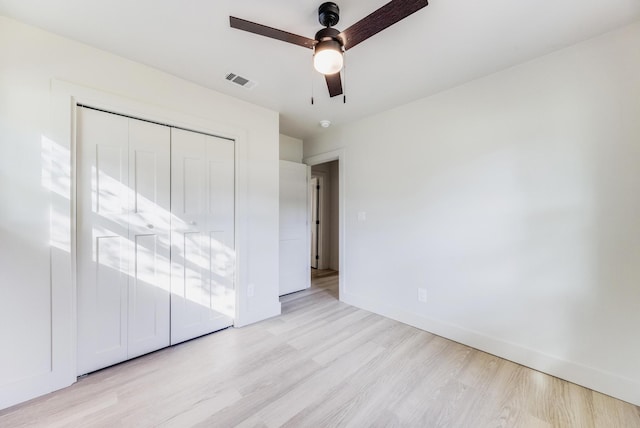 unfurnished bedroom with a closet, visible vents, light wood-style flooring, and baseboards